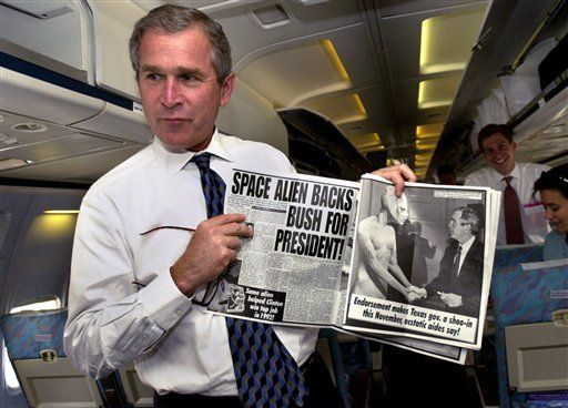 George W. Bush showing a newspaper with a humorous campaign headline