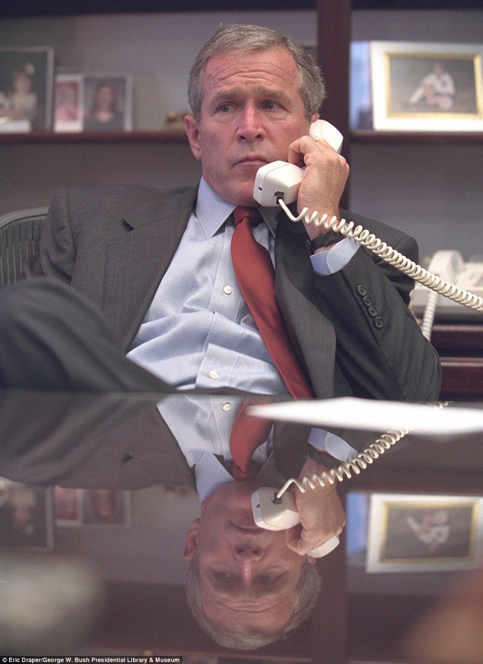 George W. Bush speaking on a phone in an office