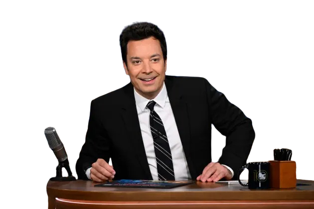 Jimmy Fallon seated behind The Tonight Show desk