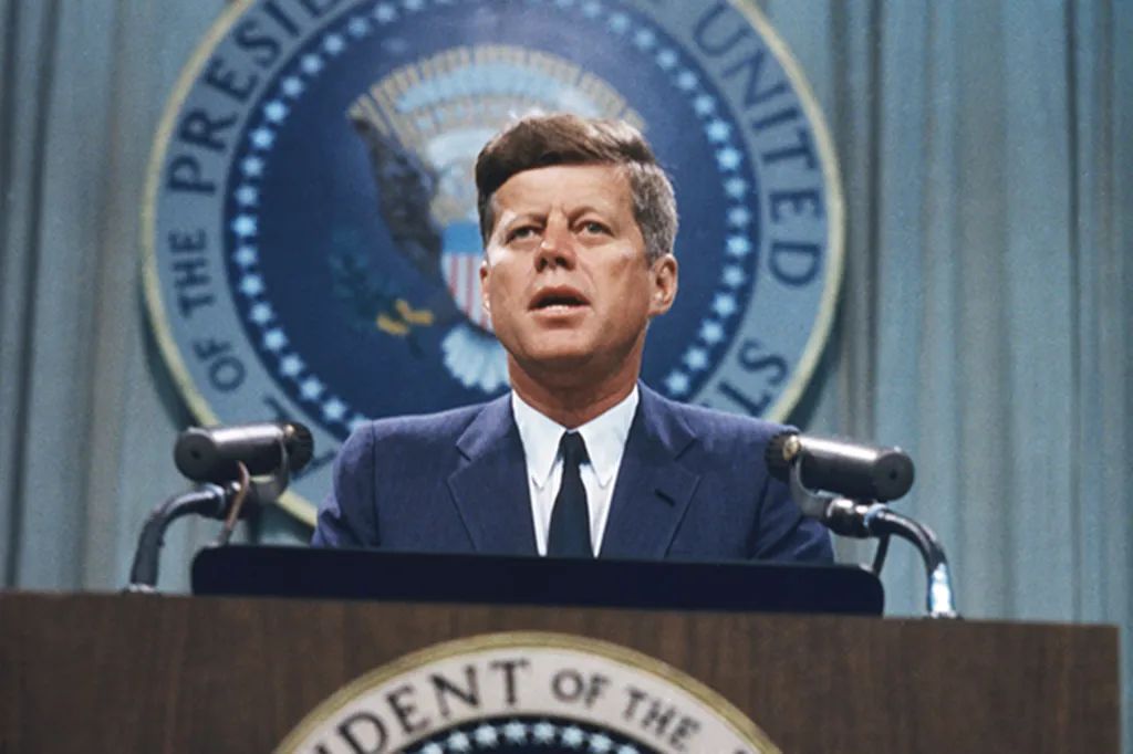 John F. Kennedy speaking at a podium